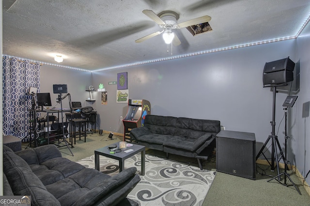 living room featuring carpet, a ceiling fan, and a textured ceiling