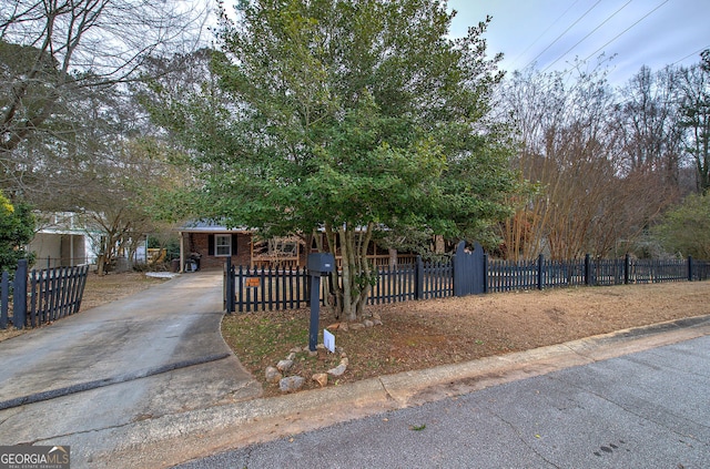 view of front of house featuring a fenced front yard, brick siding, and driveway