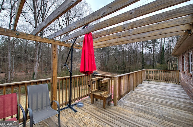 deck featuring a wooded view and a pergola