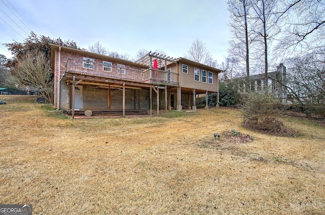 rear view of property featuring brick siding, a yard, and a wooden deck