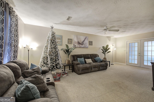 living area featuring ceiling fan, french doors, a textured ceiling, and carpet