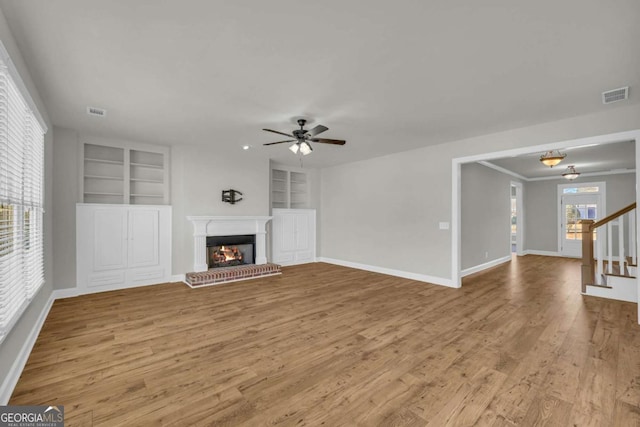 unfurnished living room featuring ceiling fan, light hardwood / wood-style floors, and built in features