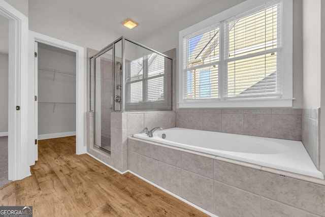 bathroom featuring plus walk in shower and hardwood / wood-style flooring