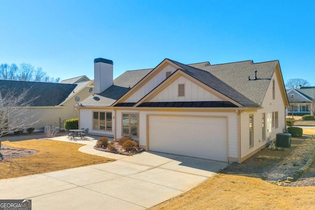 view of front of home with a garage and central AC