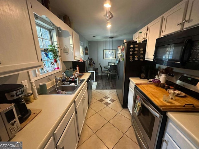 kitchen with sink, light tile patterned floors, track lighting, white cabinets, and appliances with stainless steel finishes