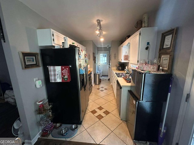 kitchen featuring white cabinets, stainless steel appliances, and light tile patterned flooring