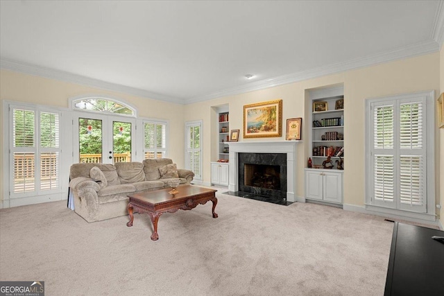 carpeted living room with a healthy amount of sunlight, a premium fireplace, built in features, and crown molding