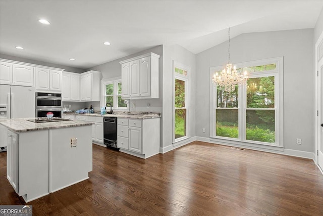 kitchen featuring white refrigerator with ice dispenser, double oven, decorative light fixtures, vaulted ceiling, and white cabinets