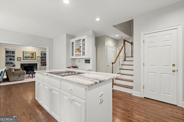 kitchen featuring black electric cooktop, white cabinetry, dark hardwood / wood-style flooring, and light stone counters