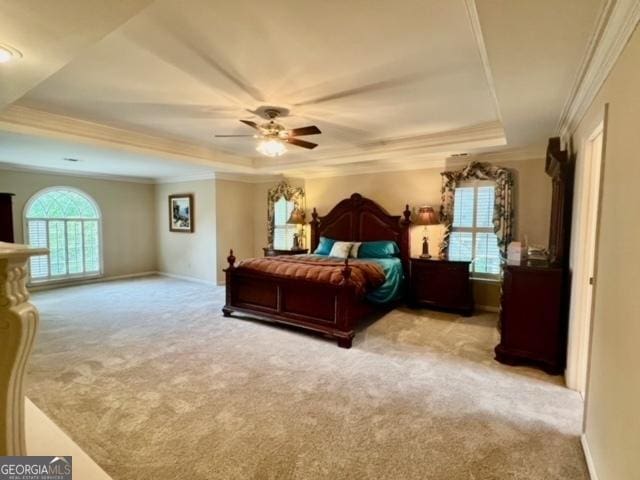 bedroom featuring light carpet, a raised ceiling, ceiling fan, crown molding, and multiple windows