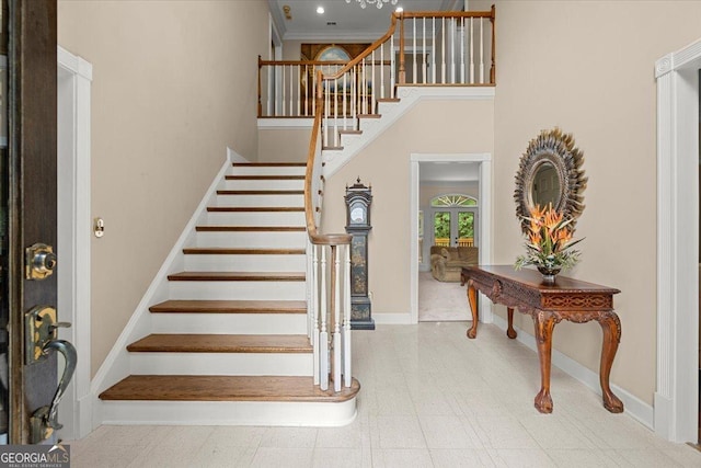 entrance foyer with a towering ceiling and ornamental molding