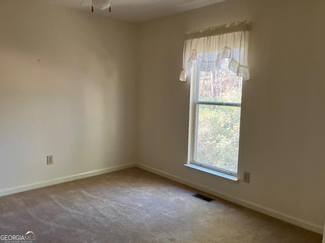 spare room with carpet flooring and ceiling fan