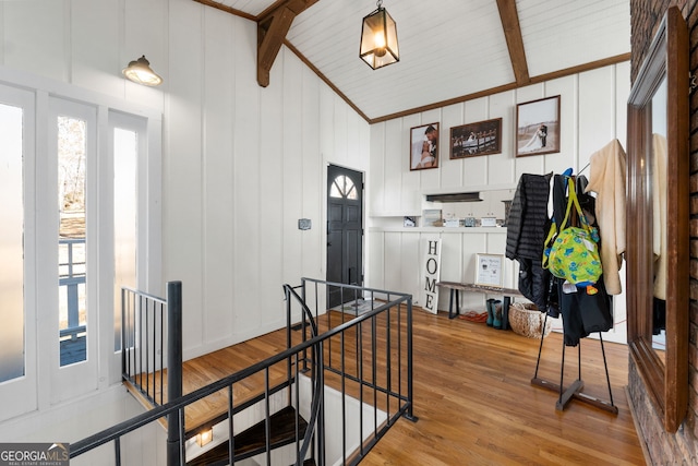 foyer featuring vaulted ceiling with beams and light wood-type flooring