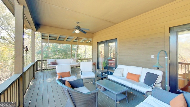 wooden deck featuring an outdoor living space and ceiling fan