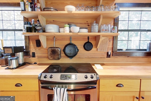 kitchen featuring stainless steel electric range oven and wooden counters