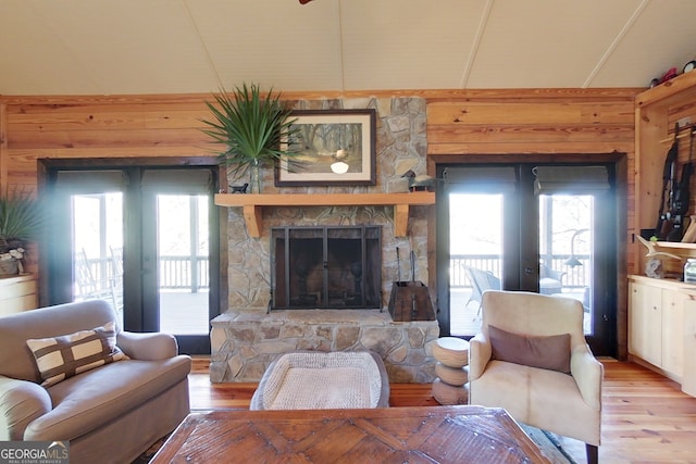 living room with hardwood / wood-style flooring, a fireplace, and french doors