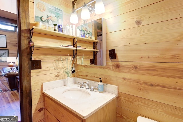 bathroom featuring wooden walls and vanity