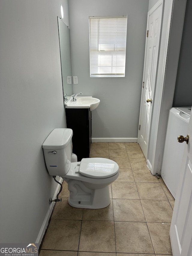 bathroom with toilet, vanity, washer / clothes dryer, and tile patterned floors