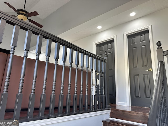 stairs featuring ceiling fan