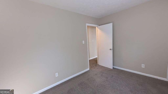 empty room featuring dark colored carpet