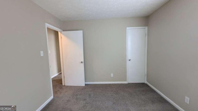 unfurnished bedroom featuring carpet and a textured ceiling