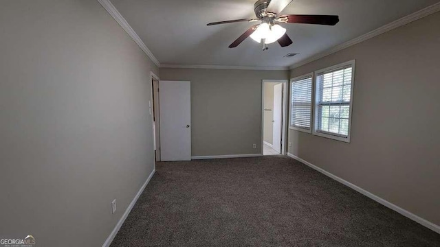 spare room with crown molding, ceiling fan, and dark colored carpet