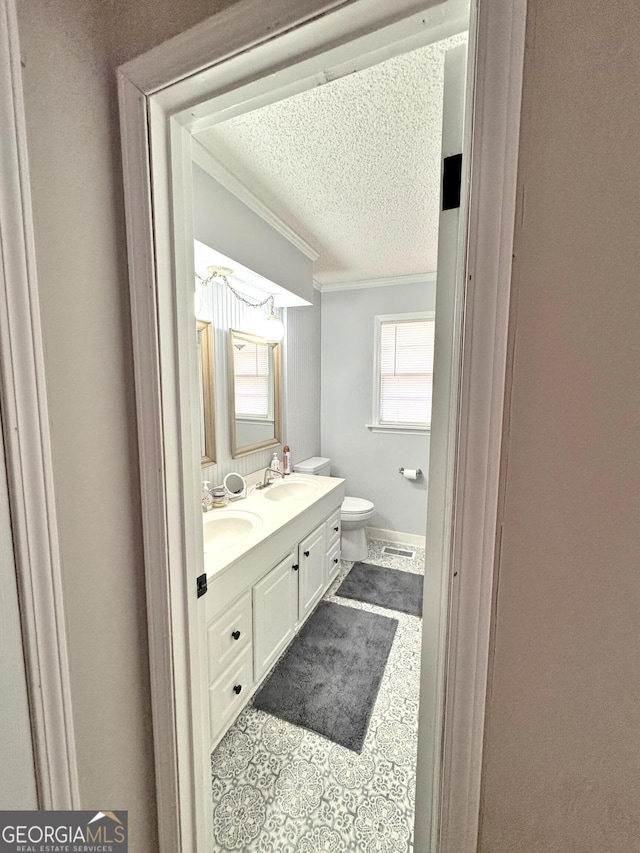 bathroom featuring vanity, a textured ceiling, toilet, and ornamental molding