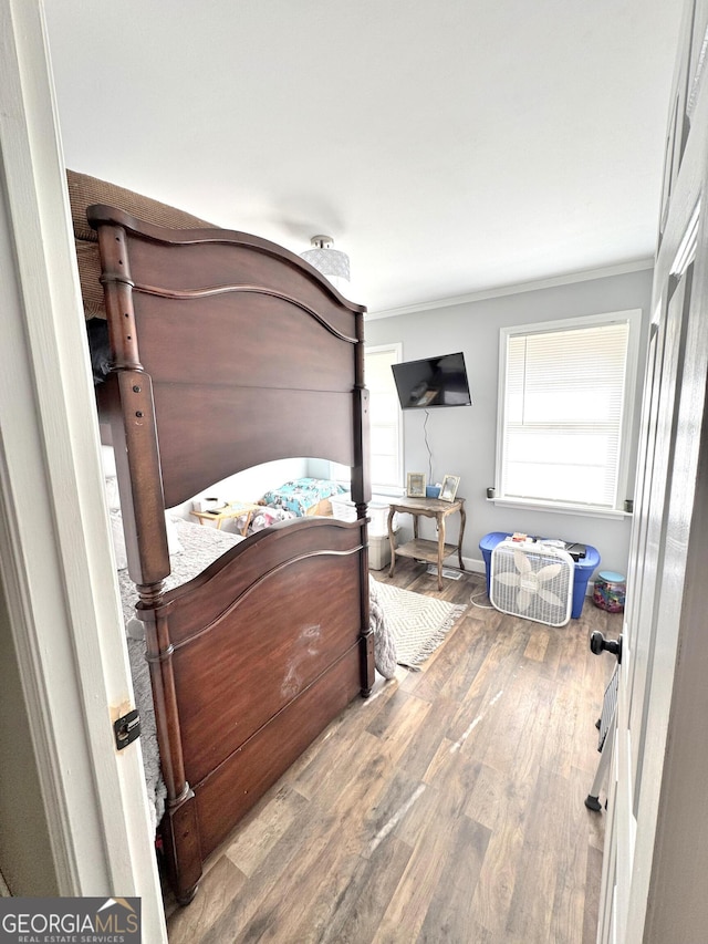 bedroom featuring wood-type flooring and crown molding