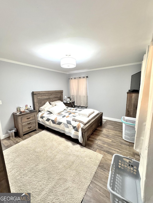 bedroom featuring crown molding and dark hardwood / wood-style floors