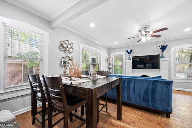 dining room featuring ceiling fan, beamed ceiling, wood-type flooring, and ornamental molding