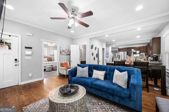 living room featuring wood-type flooring, a wealth of natural light, ceiling fan, and ornamental molding