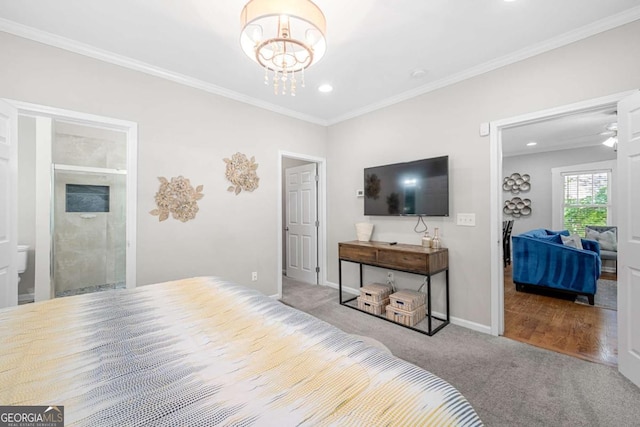 carpeted bedroom with ensuite bath, a chandelier, and ornamental molding