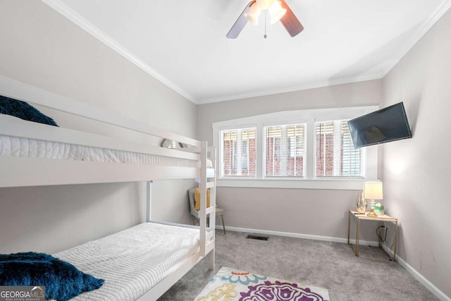 carpeted bedroom featuring ceiling fan and crown molding