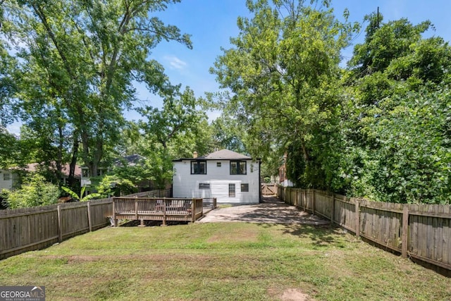 rear view of house with a yard and a wooden deck