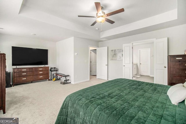 bedroom with a raised ceiling, light carpet, and ceiling fan