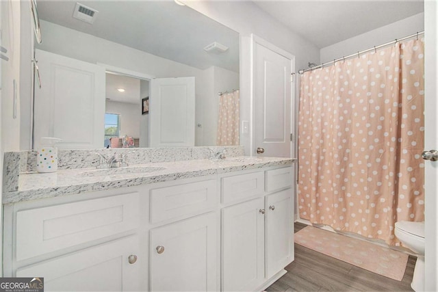 bathroom featuring toilet, curtained shower, wood-type flooring, and vanity