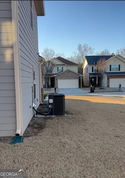 exterior space with a garage and cooling unit