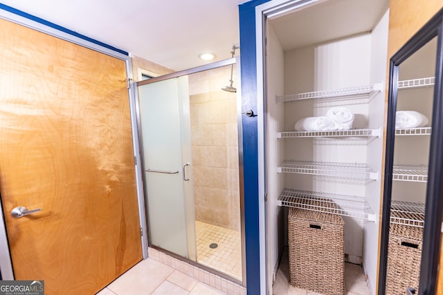 full bathroom featuring tile patterned flooring and a shower stall