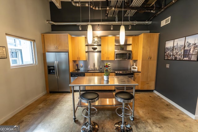 kitchen featuring stainless steel appliances, visible vents, a sink, and baseboards