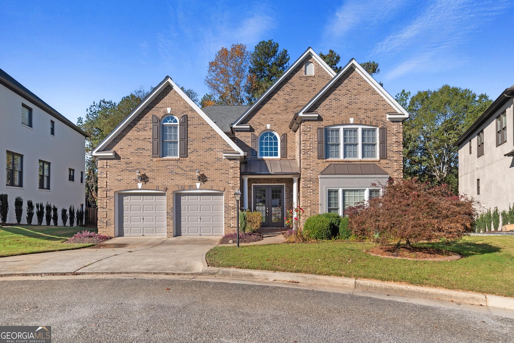 front of property featuring a front yard, french doors, and a garage