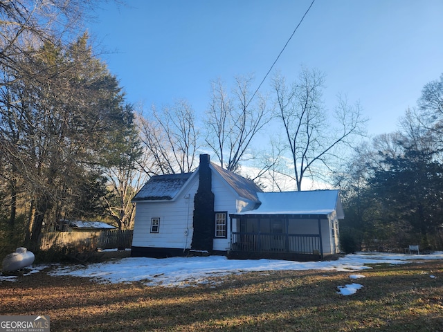 view of snow covered exterior featuring a lawn