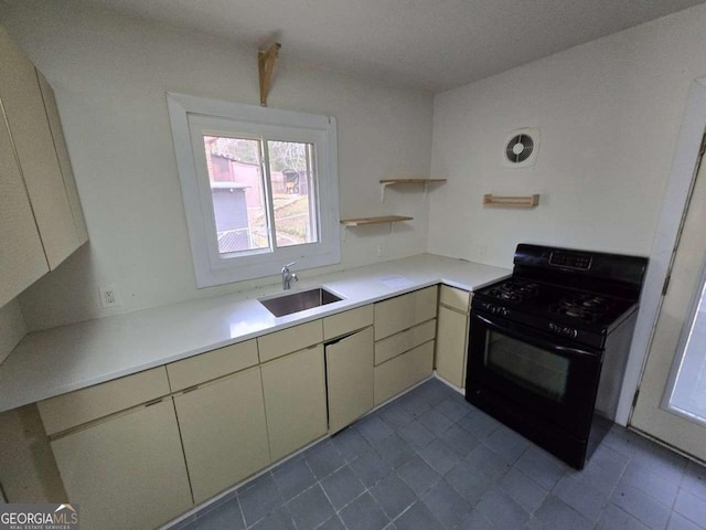 kitchen with black range with gas stovetop, sink, and cream cabinets