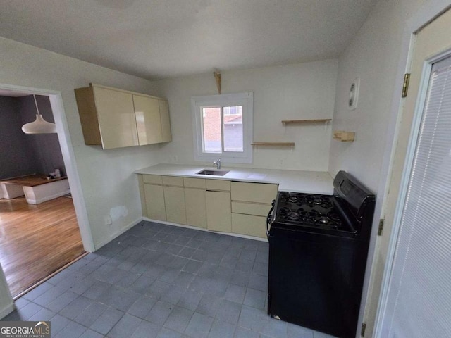 kitchen featuring cream cabinets, black range oven, and sink