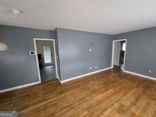 empty room with dark wood-type flooring