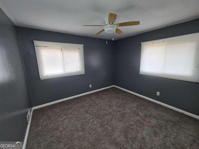 carpeted spare room featuring plenty of natural light and ceiling fan