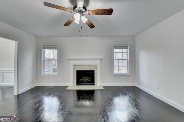 unfurnished living room featuring ceiling fan, dark hardwood / wood-style flooring, and a high end fireplace