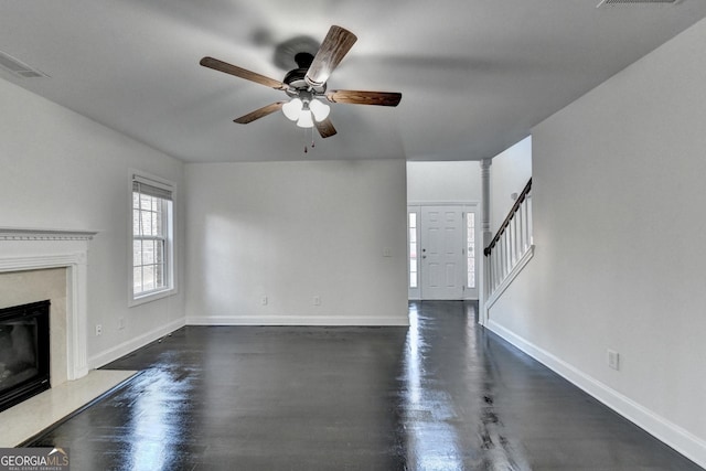 unfurnished living room featuring ceiling fan and a premium fireplace