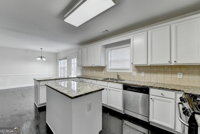 kitchen featuring appliances with stainless steel finishes, sink, decorative light fixtures, white cabinetry, and a kitchen island