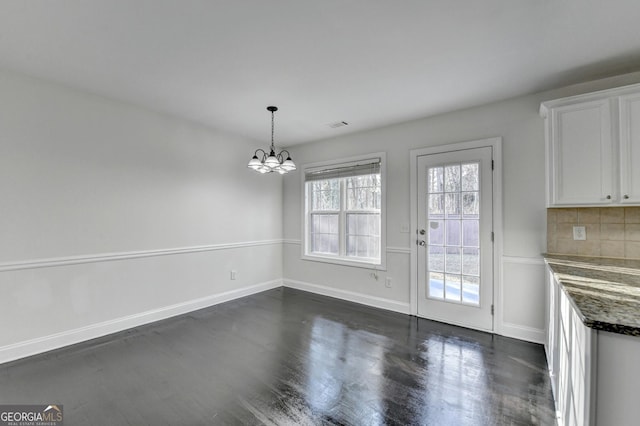 unfurnished dining area featuring a chandelier