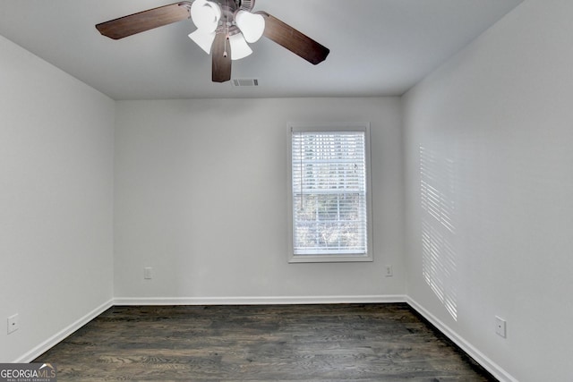 empty room with ceiling fan and dark hardwood / wood-style flooring